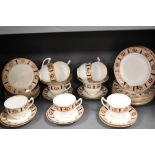 An assortment of breakfast cups and saucers and side plates, having white ground with dappled border