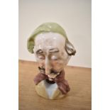 A continental porcelain figural ashtray, in the form of an old man with moustache, measuring 13cm