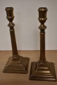 A pair of 19th Century bell metal alloy candle holders, measuring 27cm tall