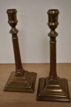 A pair of 19th Century bell metal alloy candle holders, measuring 27cm tall