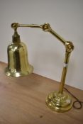 An Edwardian brass adjustable desk lamp, raised upon a stepped circular base, measuring 40cm tall
