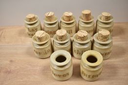 A group of 11 vintage stoneware herb jars, most with cork stoppers, and each measuring 19cm tall