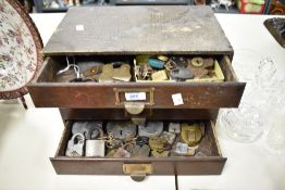 A set of vintage wooden drawers, containing and assortment of vintage and antique padlocks.