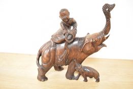 A 19th Century Chinese carved hardwood ornament of a man bathing an elephant with its calf,