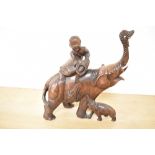 A 19th Century Chinese carved hardwood ornament of a man bathing an elephant with its calf,