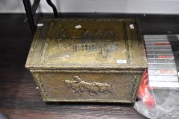 A vintage brass slipper box, having embossed cottage and hunting scenes.