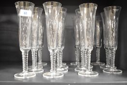 A group of fifteen modern Underberg glass champagne flutes, with twist stems, and having etched