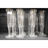 A group of fifteen modern Underberg glass champagne flutes, with twist stems, and having etched