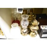 A collection of oil lamps, glass shades and chimneys.