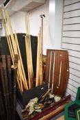 A collection of vintage pool cues, an antique score board and a slection of pockets.