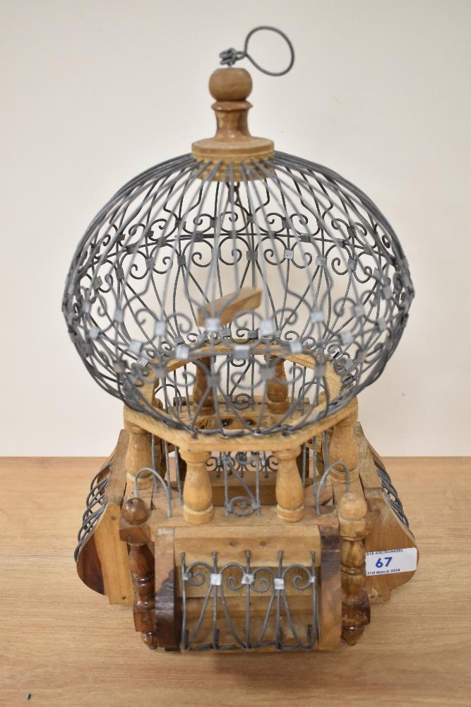 A 20th Century African wrought iron and wooden bird cage, of balloon shape, measuring 32cm tall