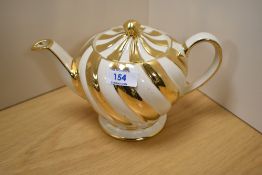 A cream and gold Sadler teapot.