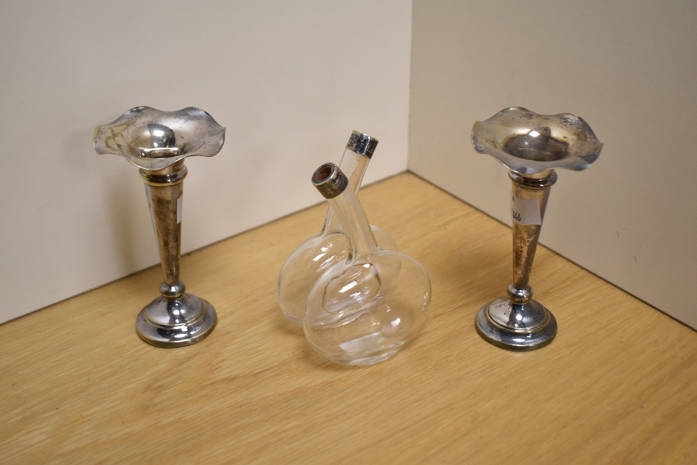 Two silver plated candlesticks of fluted form and a oil and vinegar bottle, having hallmarked silver