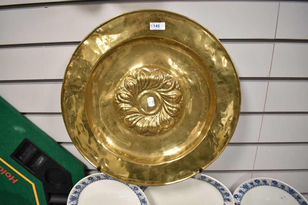 An antique Continental brass alms dish, the raised centre with a swirl of gadroons, measuring 46cm