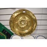 An antique Continental brass alms dish, the raised centre with a swirl of gadroons, measuring 46cm