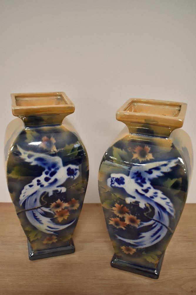 A pair of mid-20th Century glazed pottery vases of baluster form, decorated with exotic birds,