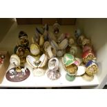 A selection of decorative ornamental eggs, with figures and animals to centres.