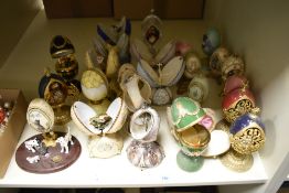 A selection of decorative ornamental eggs, with figures and animals to centres.