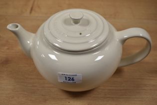 A cream Le Creuset teapot.