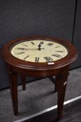 A vintage stained wood coffee table, having an integral working clock within, measuring 55cm tall