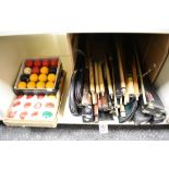 A collection of pool / snooker balls in boxes and a large amount of cues and some cases.