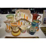 A selection of bright Art Deco hand painted Myott Pottery, including jugs, plate and vases.