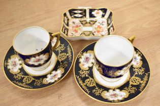 Two Victorian Coalport navy blue and white cabinet cups and saucers, and a Royal Crown Derby