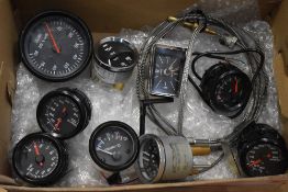 A box of automobile gauges with Black faces including Rev counter, Volt, Water/Oil, Oil x 3 and