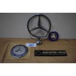 Four Mercedes car badges