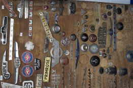 A wooden board displaying a fantastic selection of car and lorry badges