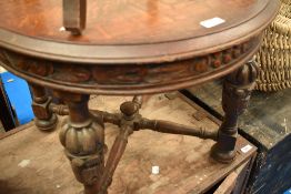 An early 20th Century oak circular coffee table having carved friese and cup and cover legs with