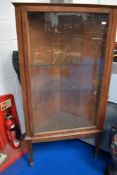 An early 20th Century oak corner display, having adjustable glass shelves (corner chip to one)