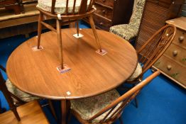 An Ercol dining set comprising drop leaf table and set of four swan back chairs