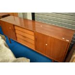 A 1960s teak Troeds sideboard having four drawers to centre, flanked by cupboards , with sliding