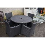 A modern plastic wicker effect garden table and four chairs