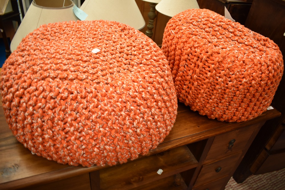 A pair of vintage knitted wool pouffe stools, in orange