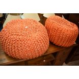 A pair of vintage knitted wool pouffe stools, in orange