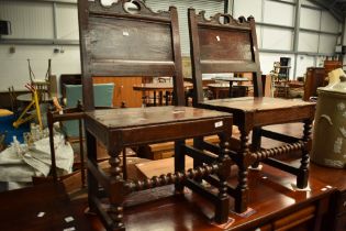 A pair of period oak hall or dining chairs , having solid back panel and plank seats and turned