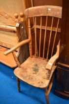 A 19th Century elm armchair of traditional form having spindle back and solid seat