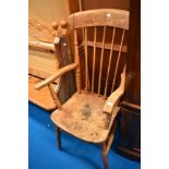 A 19th Century elm armchair of traditional form having spindle back and solid seat