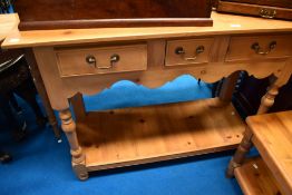 A pine side table with three drawers and under shelf, dimensions approx. 117 x 85 x 47cm