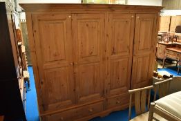 A natural pine quadruple wardrobe having double drawer base, width approx 240cm, height 205cm