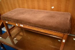An Arts and Crafts style golden oak frame footstool having upholstered top, width approx. 78cm