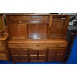 A vintage teak sideboard/dresser by Nathan, having cocktail and display section over triple frieze