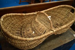 A vintage wicker fruit or flower basket, width approx. 110cm, with raised centre possibly for donkey