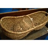 A vintage wicker fruit or flower basket, width approx. 110cm, with raised centre possibly for donkey