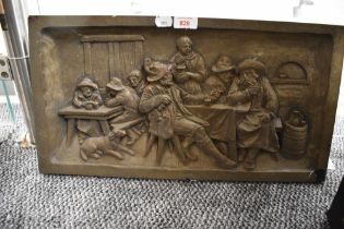 A resin moulded wall plaque, depicting a Dutch tavern scene, measuring 25cm x 50cm overall