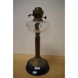 A vintage oil lamp having wheel cut glass reservoir, reeded-column and black ceramic base.