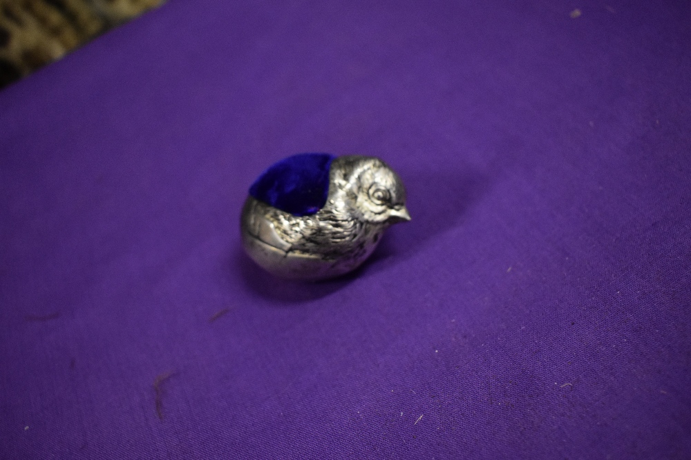 A white metal pincushion in the form of a chick, having iridescent blue/cerise velvet to top. - Image 3 of 6