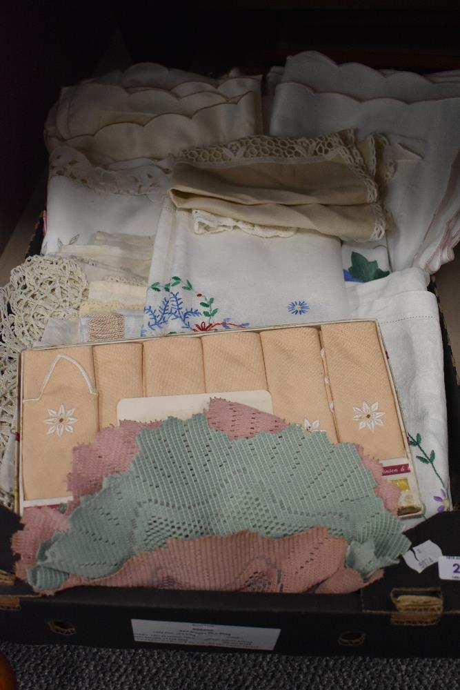 A quantity of vintage lace and embroidered table cloths, cushion covers, doilies and anti-
